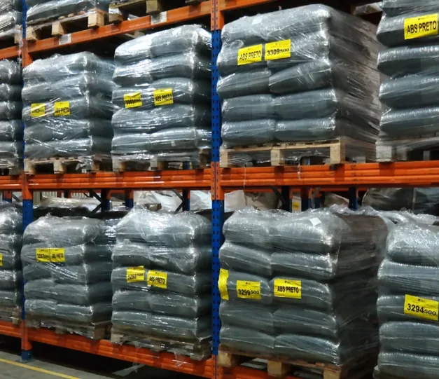 Sacos de material plástico armazenados em paletes em um galpão